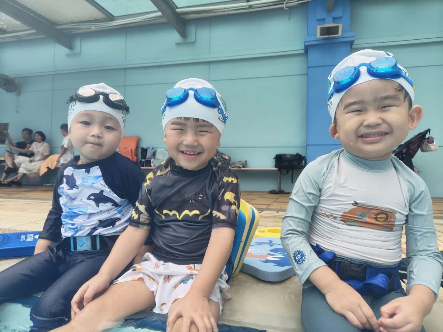 戴着 Oyougu Aquatics 泳帽,准备在新加坡上游泳课的快乐幼儿